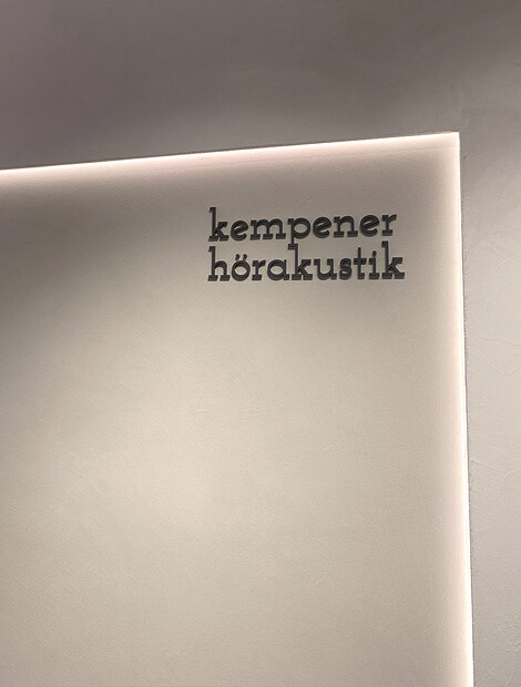 Logo auf Wand bei Kempener Hörakustik Geschäft